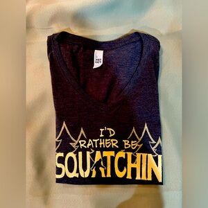 Woman’s tight-fitting, v-neck, sasquatch shirt.